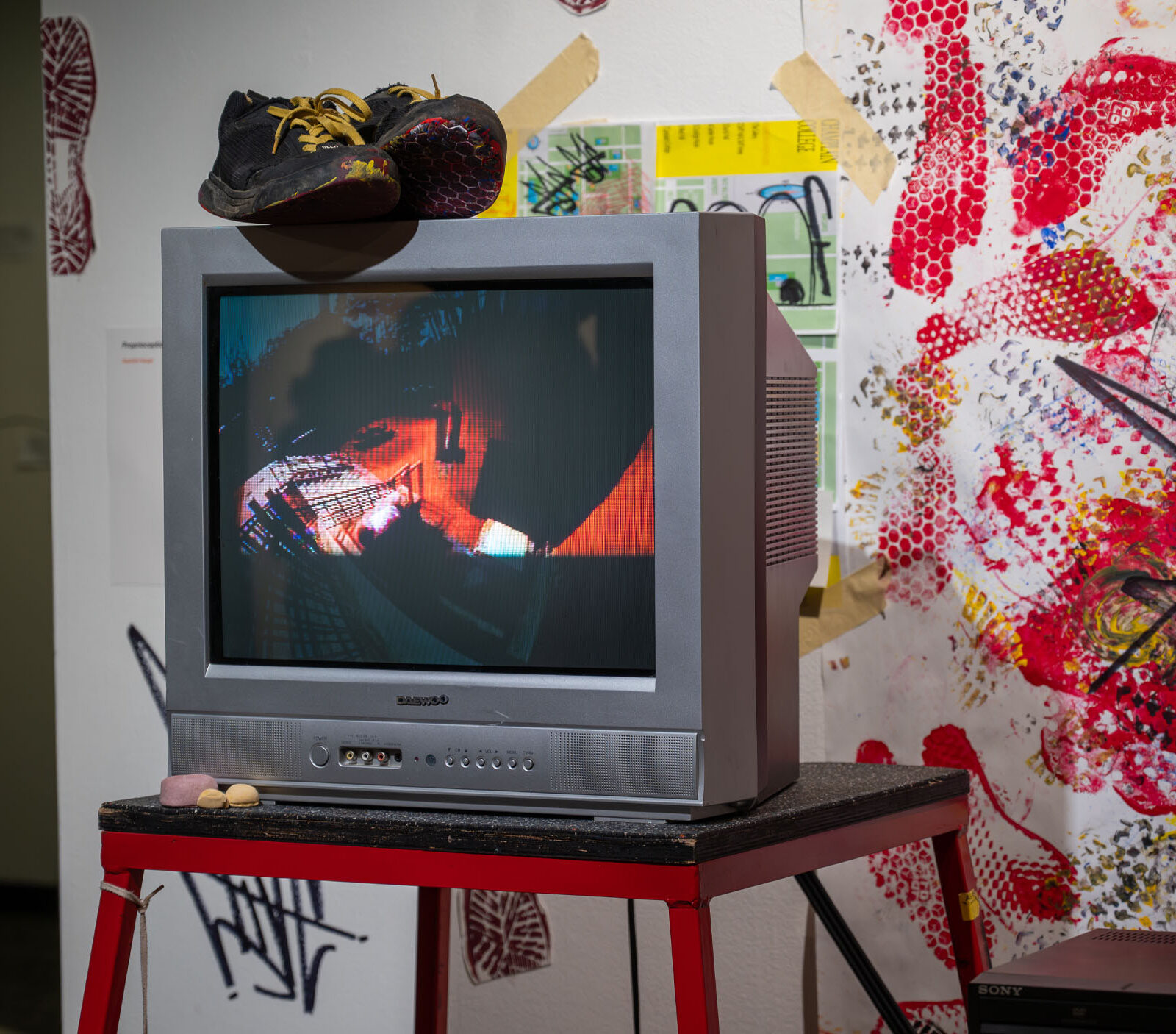 A creative media capstone gallery showcase with bright and vibrant colors featuring a tv and paint