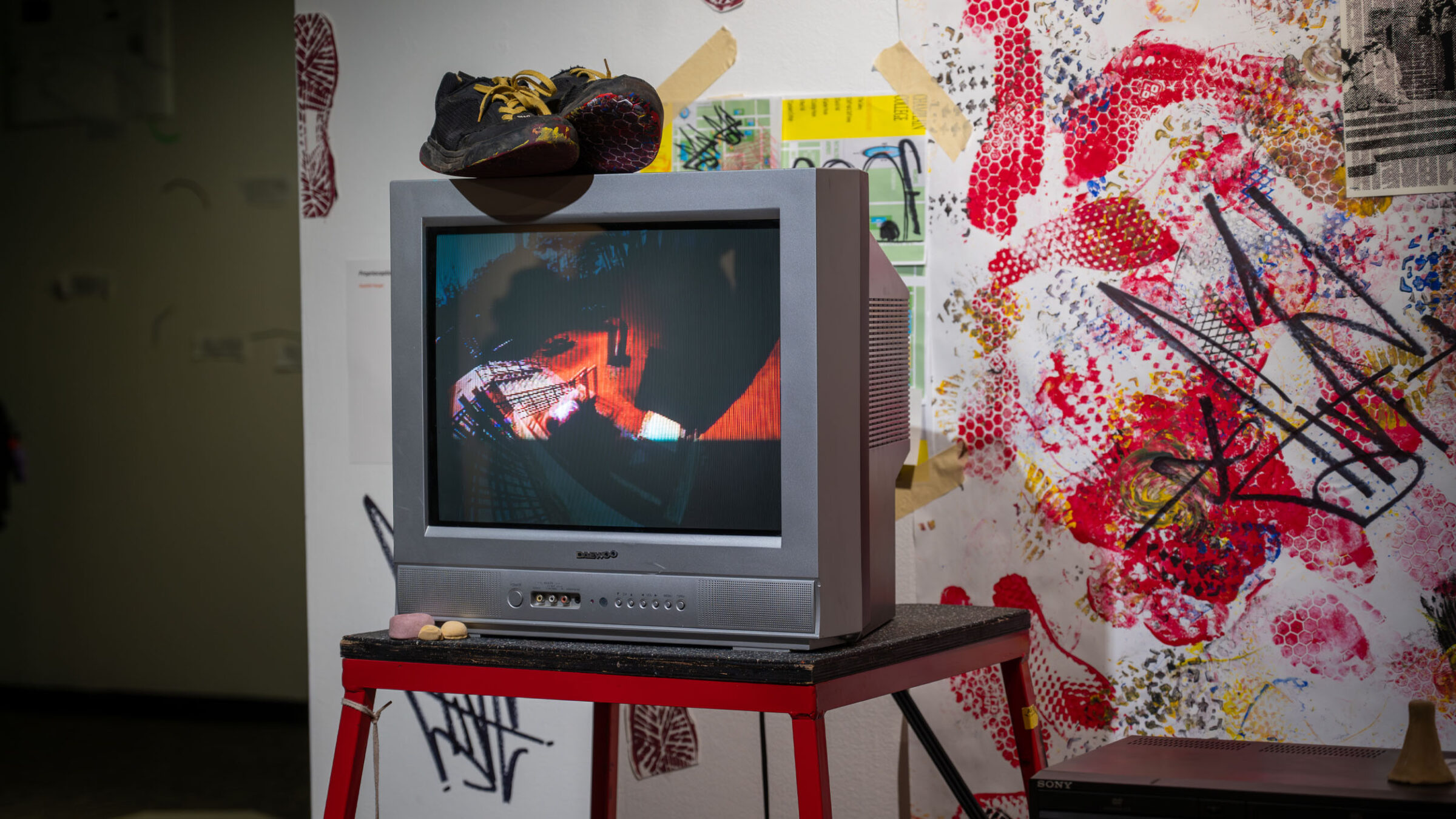 A creative media capstone gallery showcase with bright and vibrant colors featuring a tv and paint
