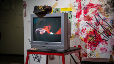A creative media capstone gallery showcase with bright and vibrant colors featuring a tv and paint