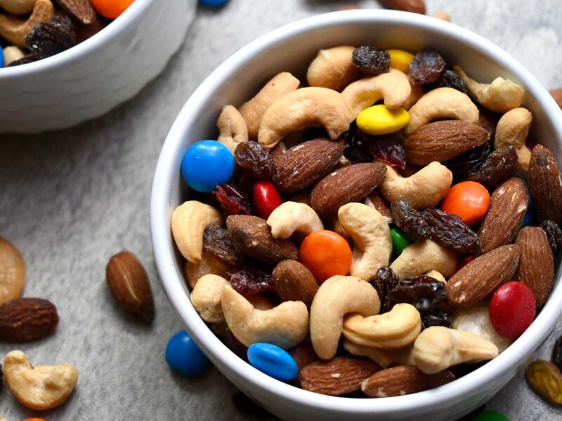 bowl of trail mix with mixed nuts, raisins, and chocolates