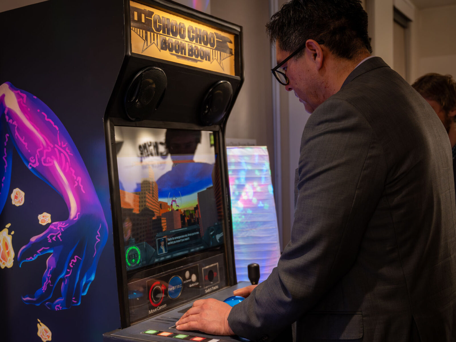 President Alex playing choo choo boom boom on an arcade cabinet during the senior game showcase