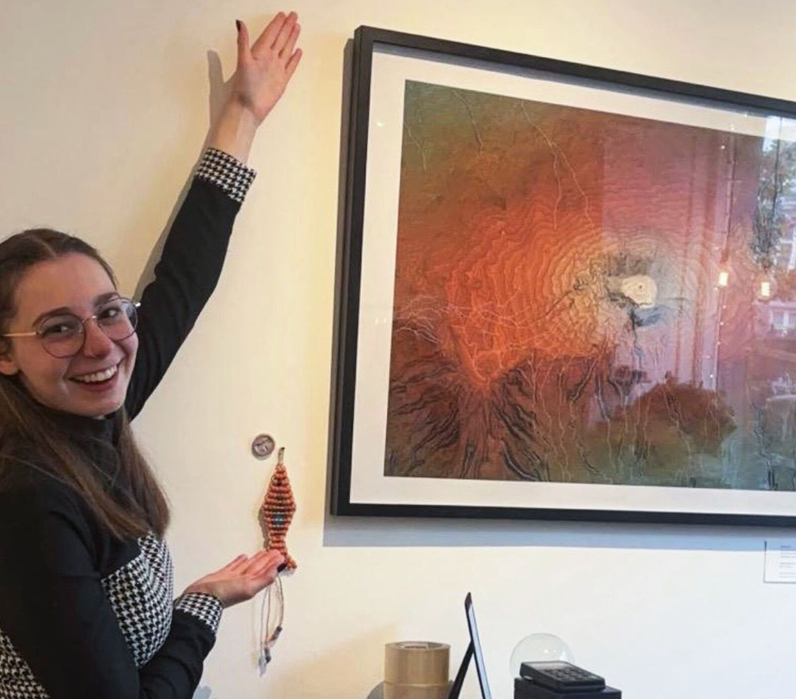 Alumni Vivi Torontali posing in front of artwork