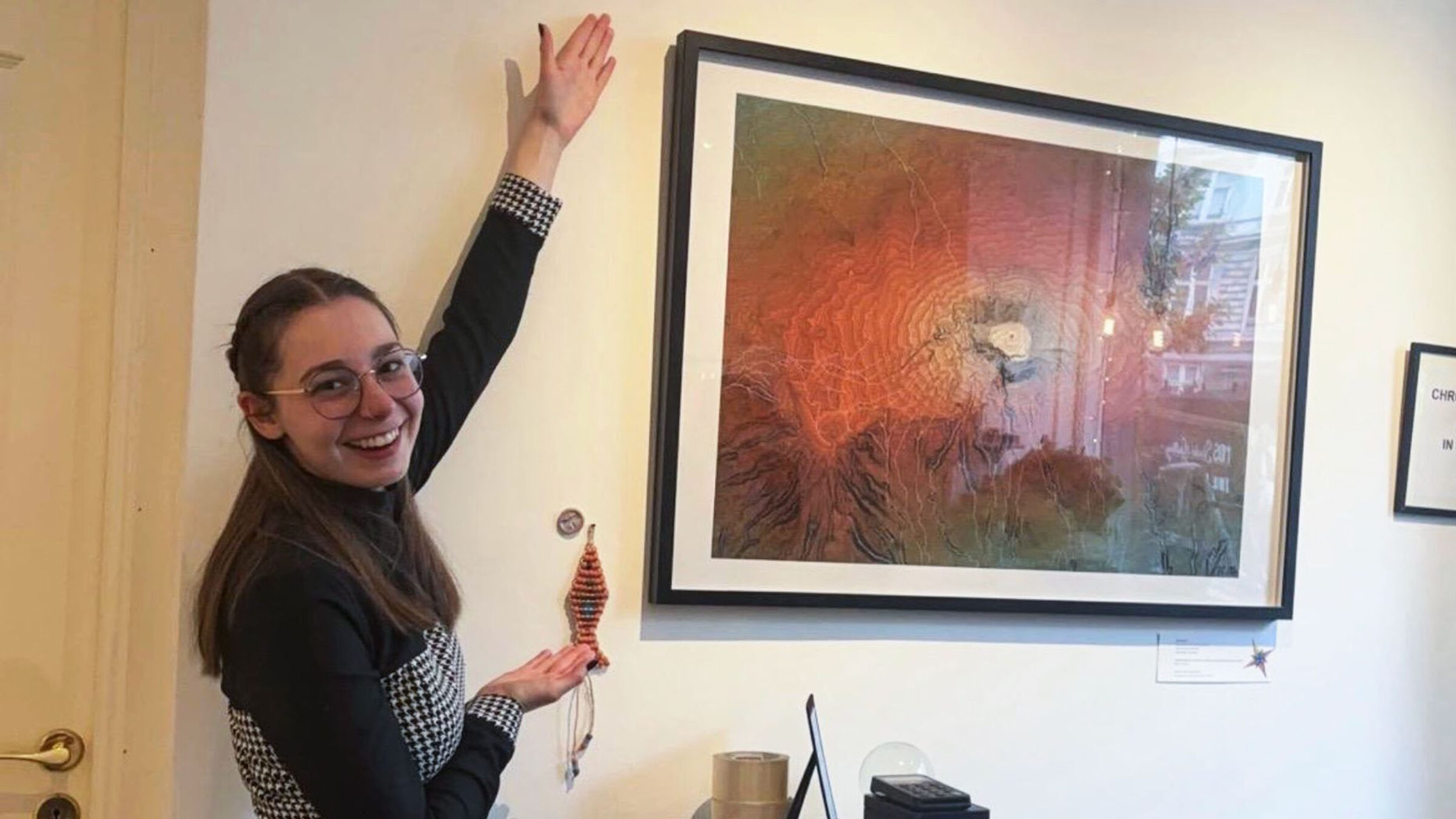Alumni Vivi Torontali posing in front of artwork