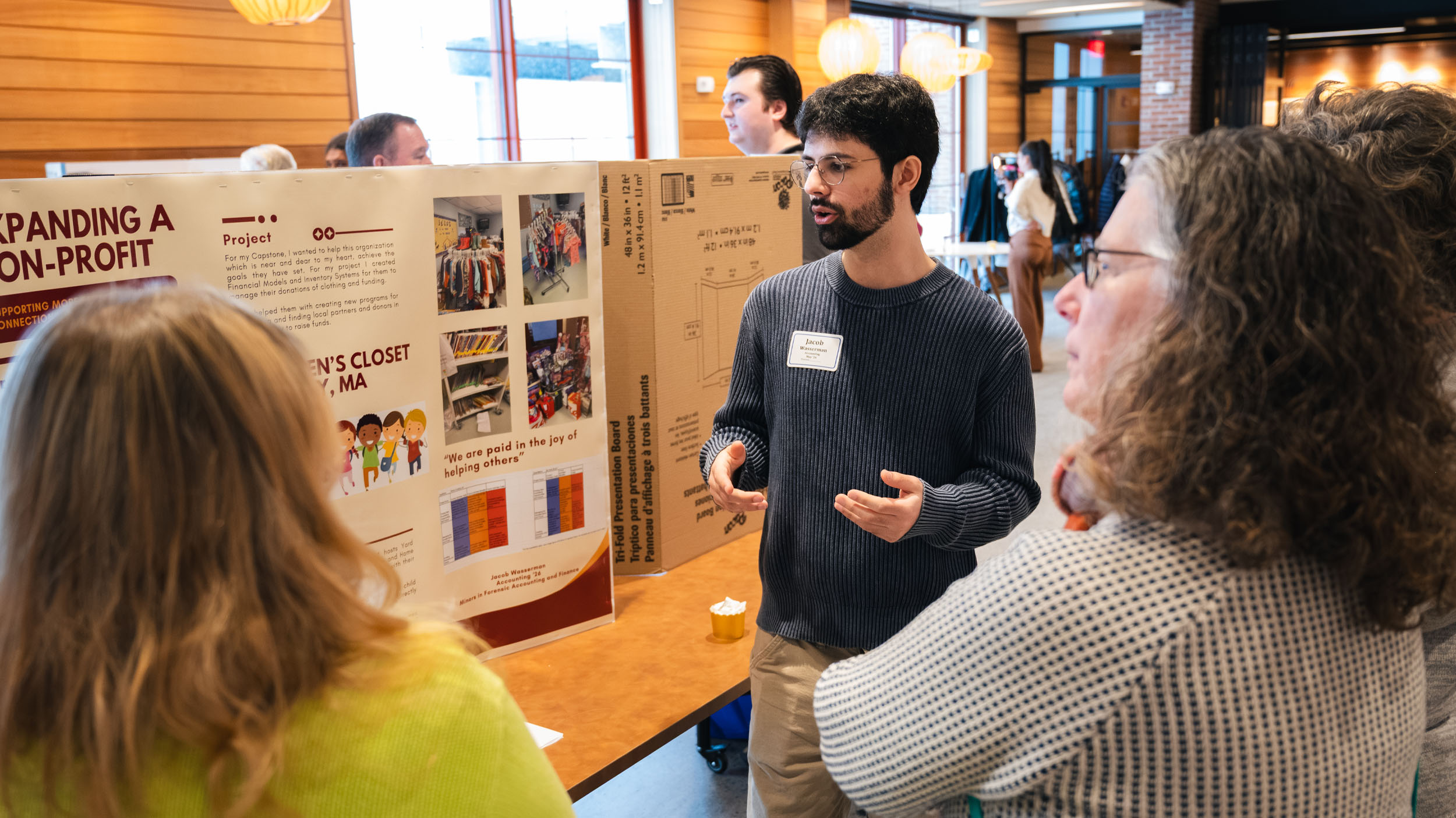Student presenting their capstone to faculty and staff on Non-profits in the Hula lounge