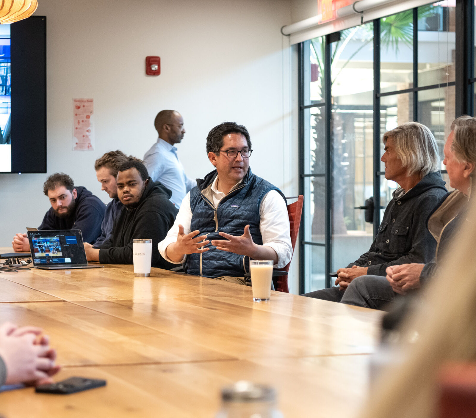 President Alex and others sitting at a table in Hula discussing business and entrepreneurship