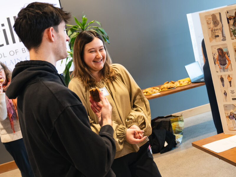 Two students talking during a capstone presentation in Hula