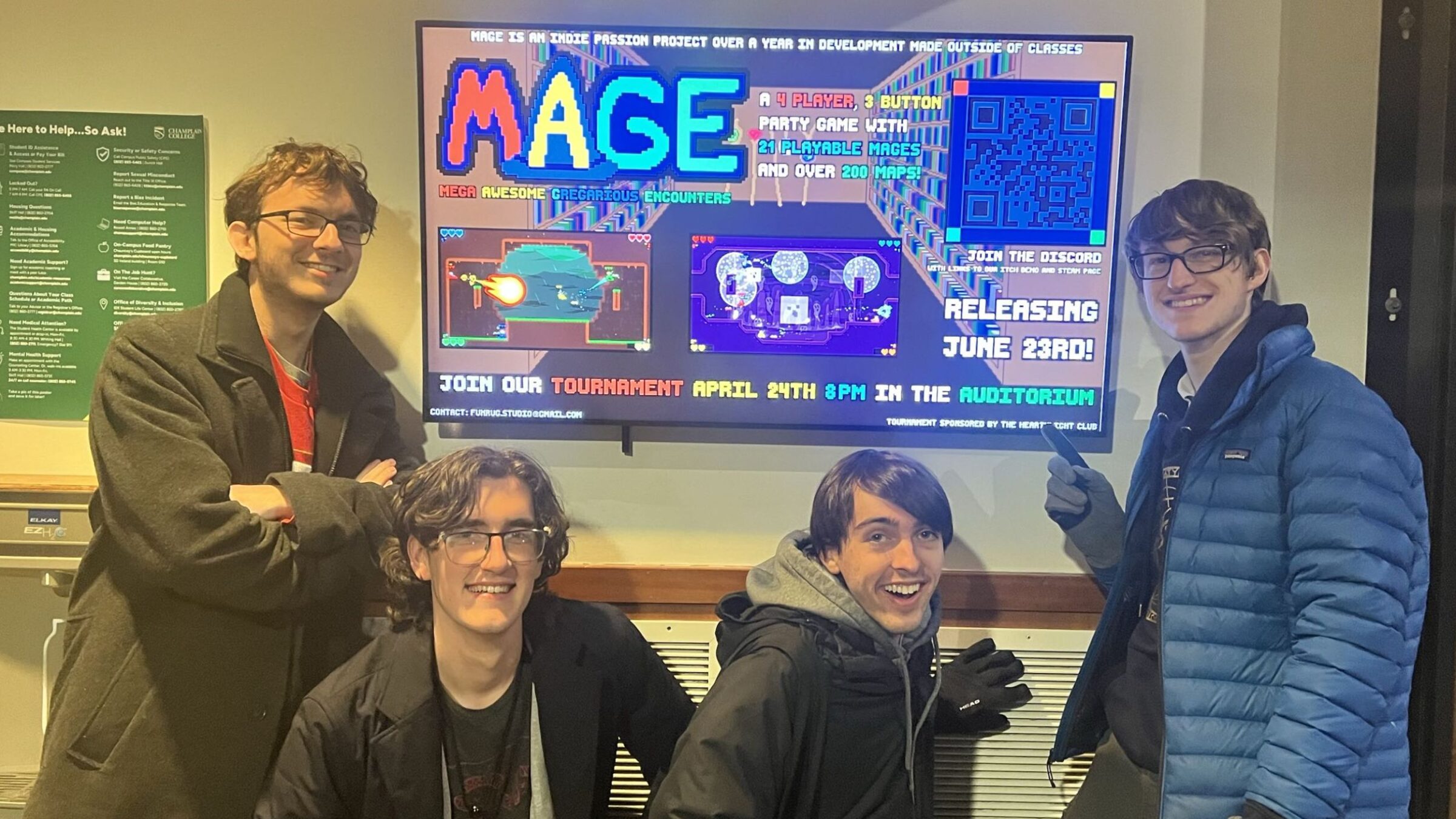 Students from the MAGE team standing in front of their game on a monitor display