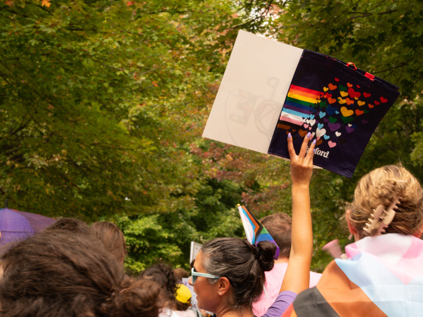 Students walking in a pride parade in Burlington Vermont holding up signs