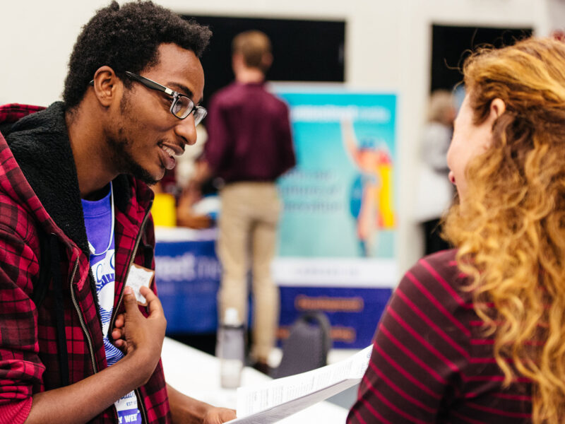 Student talks with an employer at a career fair