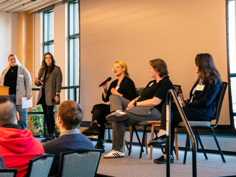Students and Alumni speaking on a panel in the Champlain room on campus