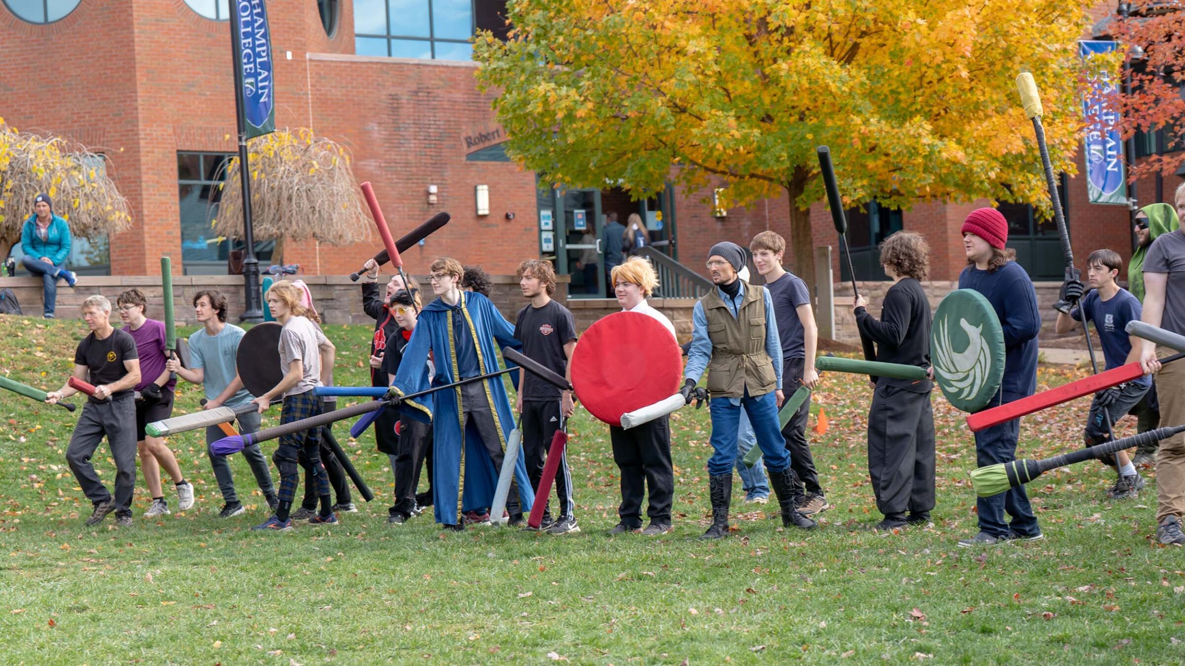 Hearthlight club group standing in line outside in the fall season on campus in front of the library
