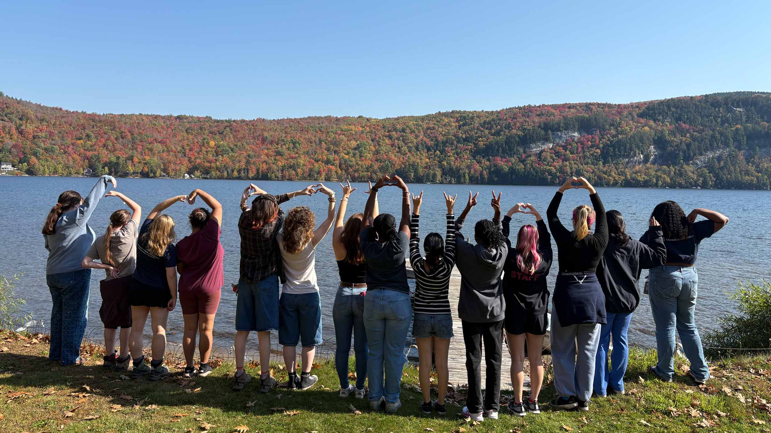 Student's from the Women & Gender Center's retreat posing for a photo in front of a Lake in Vermont