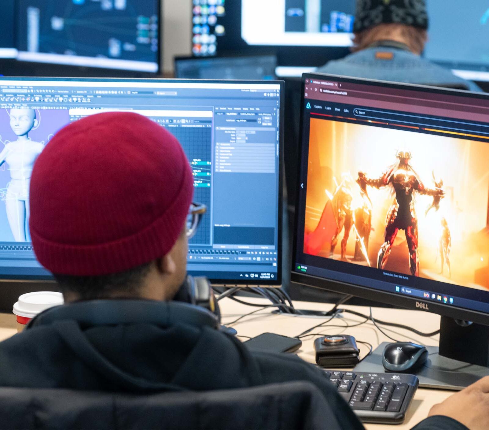 Student working on multiple monitors and building 3D animations using references