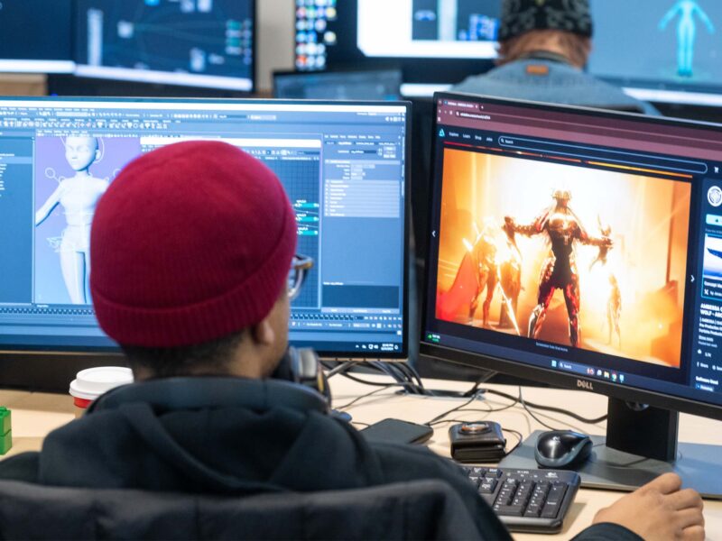 Student working on multiple monitors and building 3D animations using references