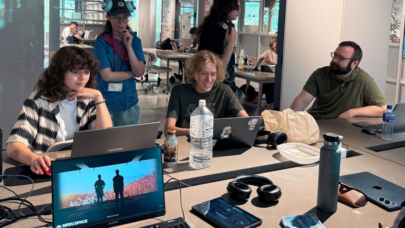 students hard at work at a table with computers