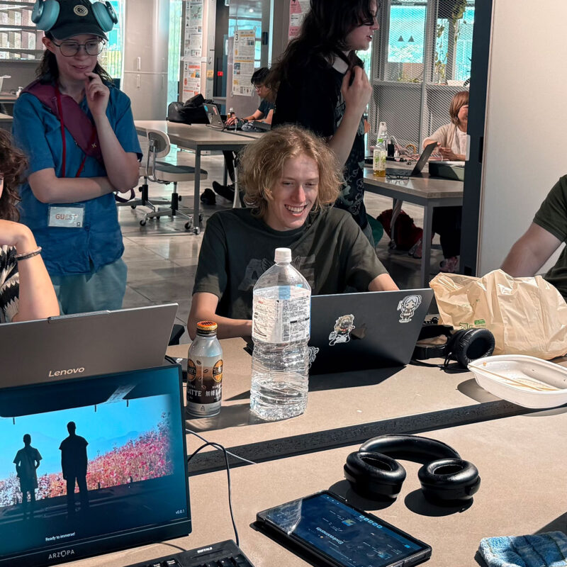 students hard at work at a table with computers