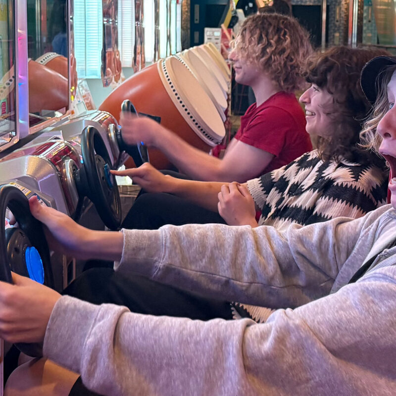students drive an arcade machine