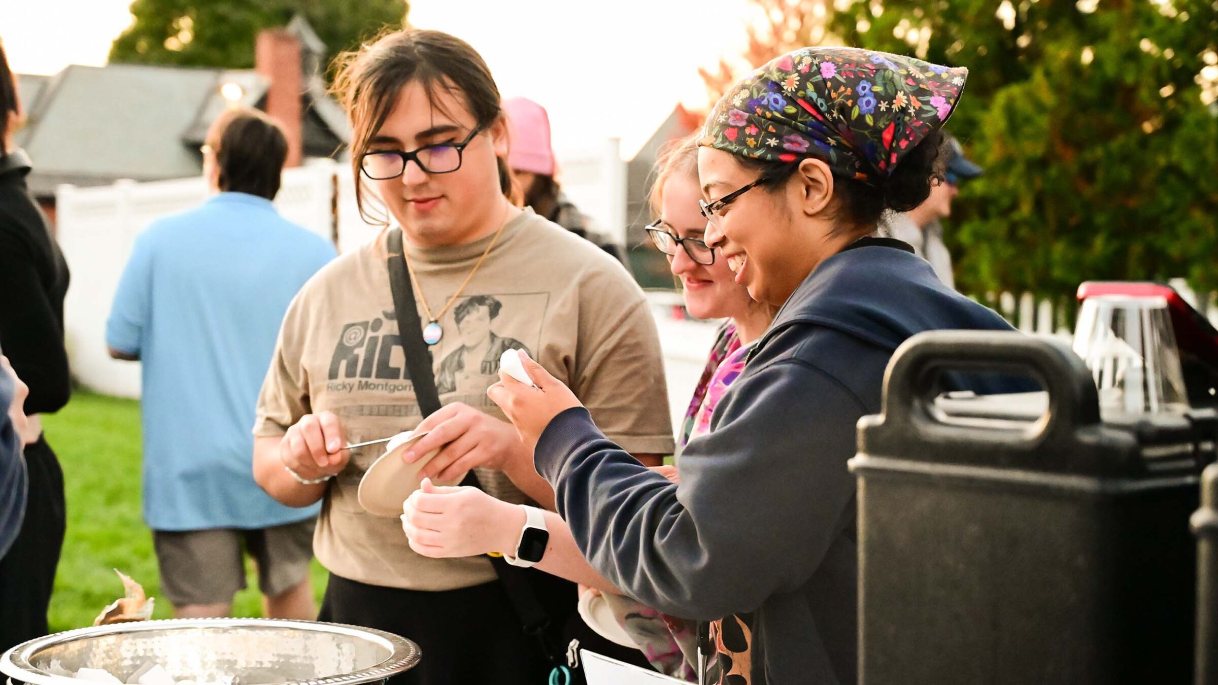 Group of students building smores outside in sunny weather