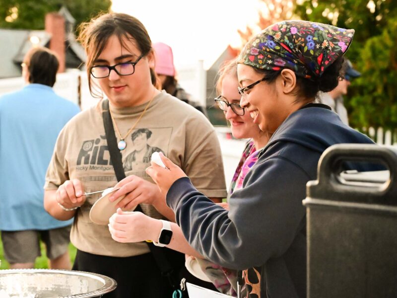 Group of students building smores outside in sunny weather