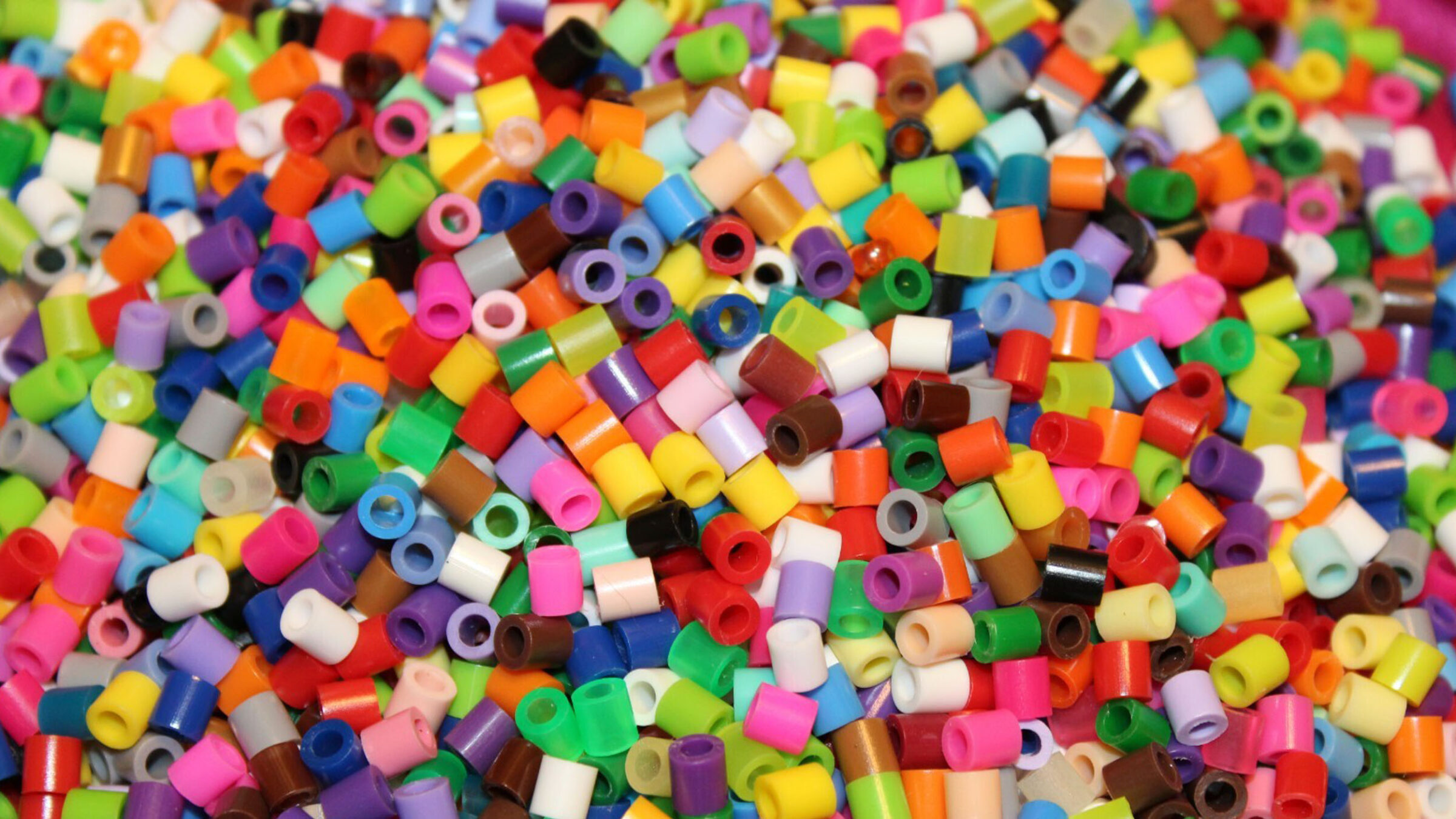 A pile of rainbow-colored pearl beads for crafting