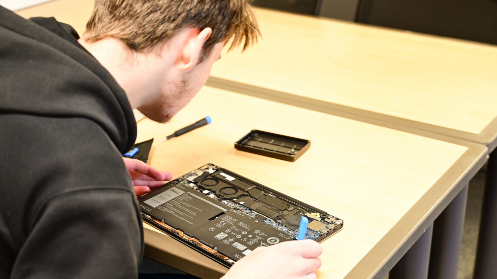 Cyber Summit student doing hands-on break it apart workshop.