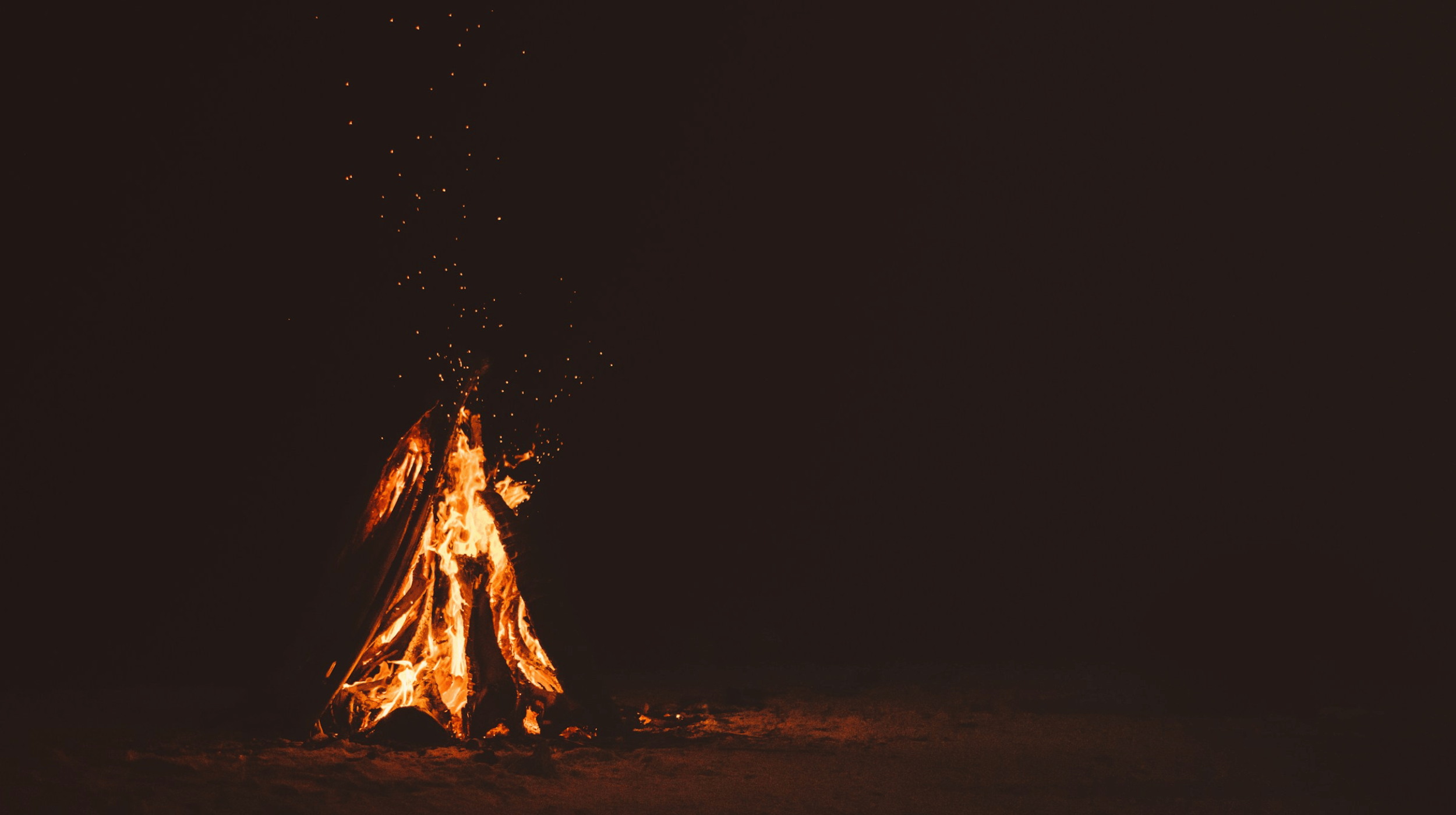 A stock photo of a black background with a campfire.