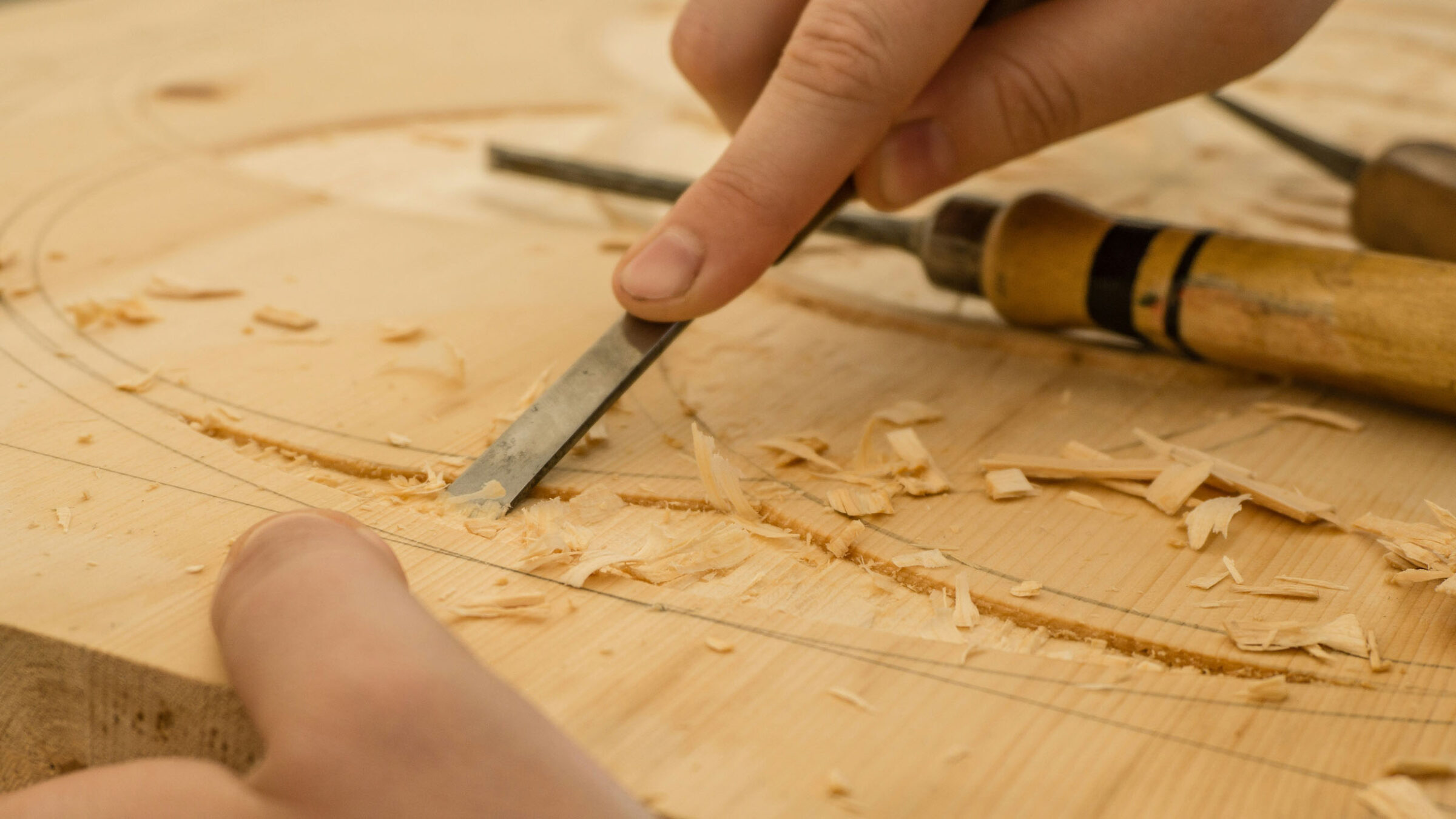 A close up photo of a person carving wood
