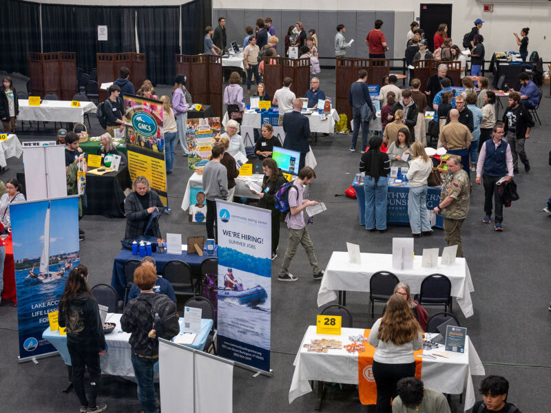 overhead view of a large group of students talking with employers at tables