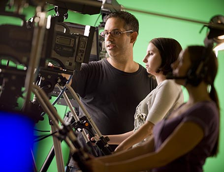 professor helping students with film equipment