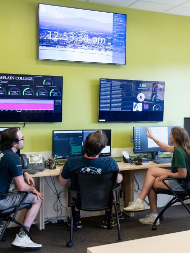 Students at computers work together in the Leahy Center 