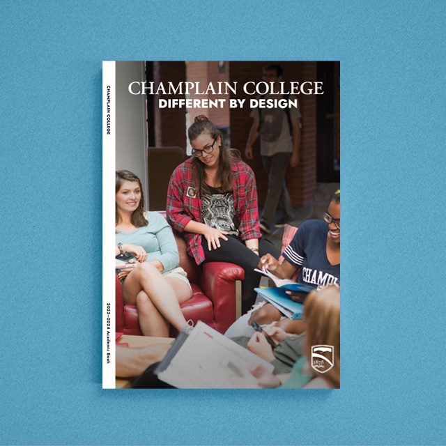 Champlain College students meet around a table on the cover of the 2023-2024 Academic Book