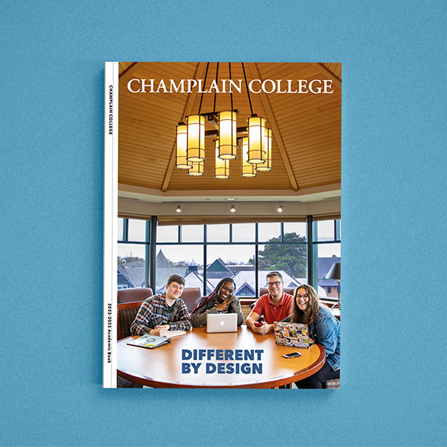 Champlain College students meet around a table on the cover of the 2021-2022 Academic Book
