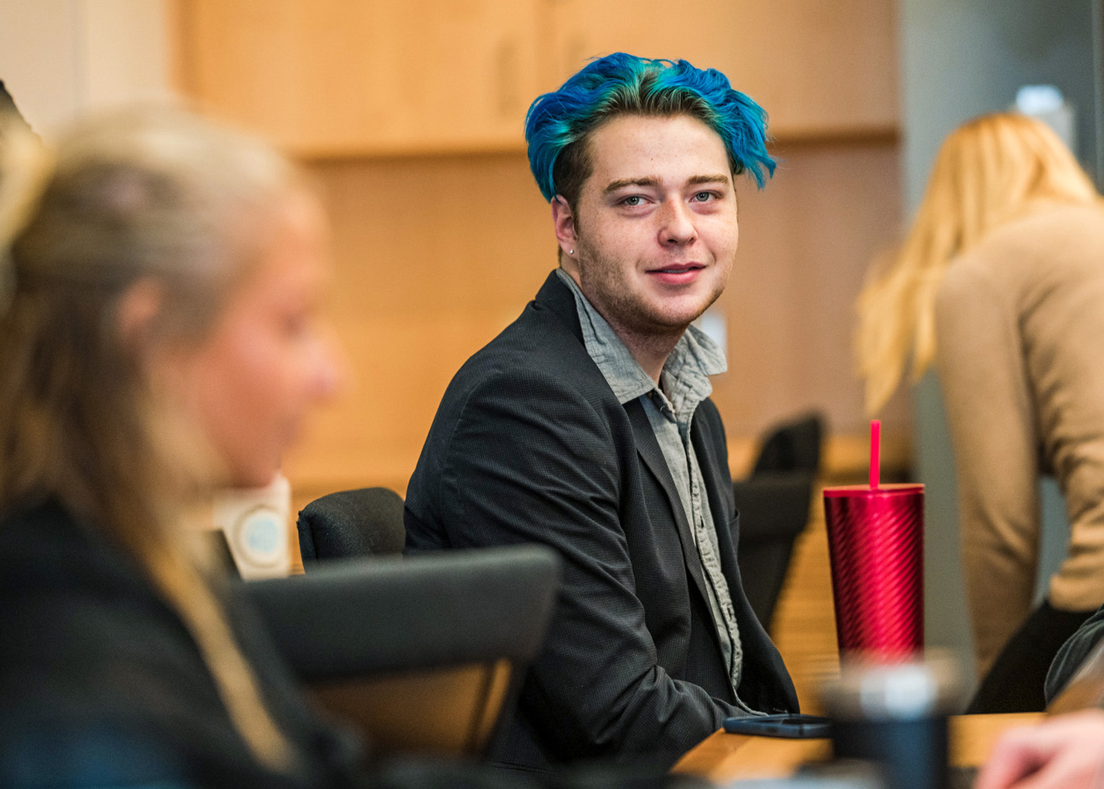student with blue hair looks at the camera