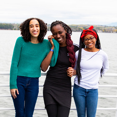 Three Champlain students pose for the camera on a boat cruise