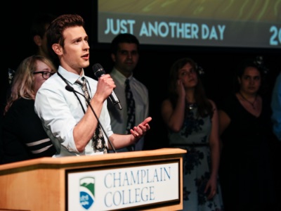 Champlain College student making a presentation from a podium in Alumni Auditorium on the Champlain College campus in Burlington, Vermont
