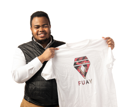 Ahmed Adan holding a shirt from his clothing brand "Fuay"