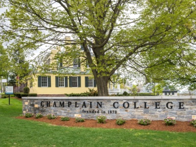 Stone fence that reads Champlain College in front of Skiff Hall at Champlain College in Burlington, Vermont.