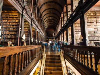 Stunning library with a wooden staircase leading up to soaring arched ceiling in Dublin, Ireland, where Champlain College has a campus.